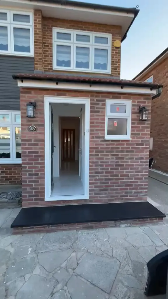 New brick entrance porch with a pitched tiled roof.