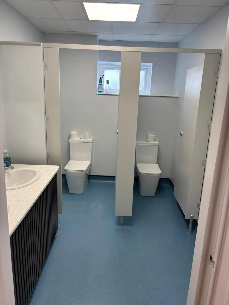 Refurbished commercial WC with new cubicles and safety flooring.
